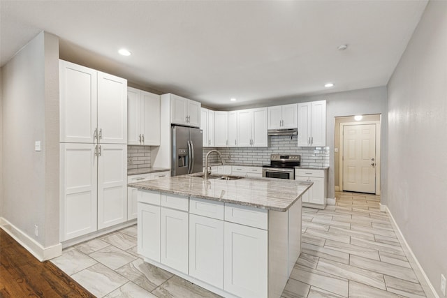 318 S Montreal Ave, Dallas, TX 75208 - kitchen featuring stainless steel appliances, a sink, baseboards, white cabinets, and a center island with sink