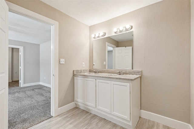 318 S Montreal Ave, Dallas, TX 75208 - full bathroom with double vanity, baseboards, and wood finished floors
