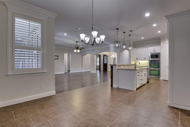 6520 Stone Creek Dr, North Richland Hills, TX 76182 - kitchen featuring arched walkways, appliances with stainless steel finishes, a chandelier, a sink, and crown molding