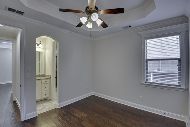 6520 Stone Creek Dr, North Richland Hills, TX 76182 - unfurnished bedroom featuring wood finished floors, arched walkways, a raised ceiling, baseboards, and ornamental molding