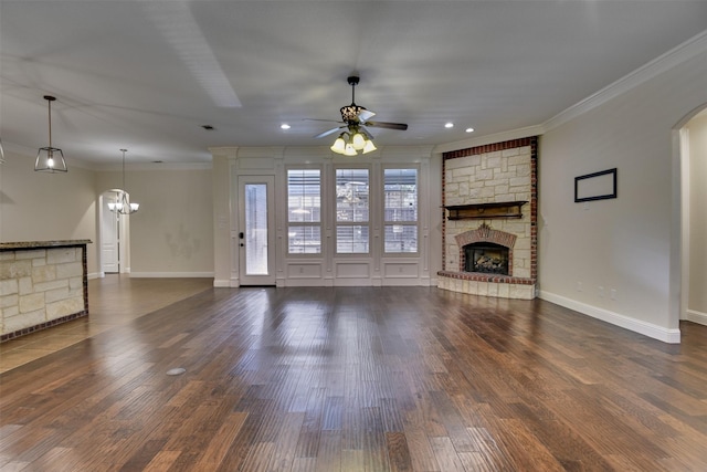 6520 Stone Creek Dr, North Richland Hills, TX 76182 - unfurnished living room featuring a stone fireplace, crown molding, a ceiling fan, recessed lighting, and dark wood-style floors
