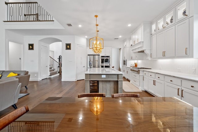 2104 Zaide Way, Celina, TX 75009 - kitchen with arched walkways, stainless steel appliances, baseboards, dark wood finished floors, and white cabinetry