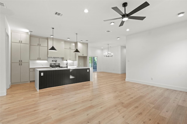 1218 Gannon Ln, Desoto, TX 75115 - kitchen featuring a chandelier, an island with sink, baseboards, light wood-style flooring, and recessed lighting