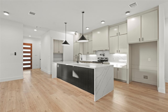 1218 Gannon Ln, Desoto, TX 75115 - kitchen featuring stainless steel electric range oven, an island with sink, light wood-style flooring, decorative light fixtures, and recessed lighting