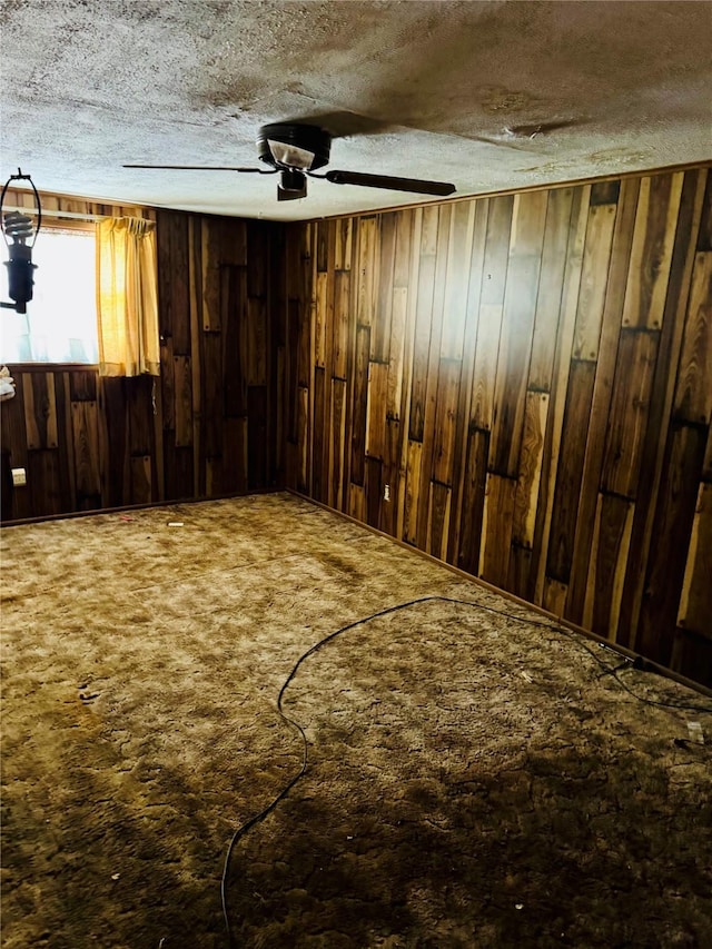 2505 Ormond Pl, Bossier City, LA 71111 - miscellaneous room with wooden walls, a ceiling fan, a textured ceiling, and carpet