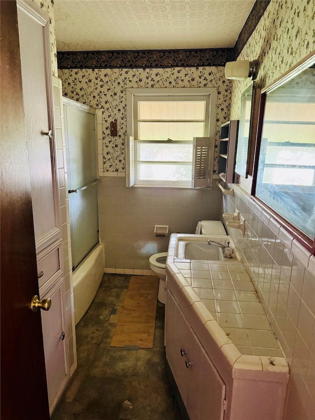 2505 Ormond Pl, Bossier City, LA 71111 - bathroom with wallpapered walls, toilet, vanity, tile walls, and a wainscoted wall