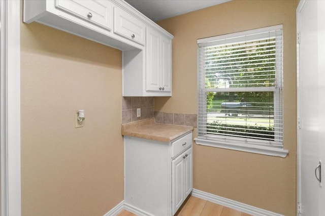 207 Mcmurry Ave, Duncanville, TX 75116 - kitchen with light countertops, white cabinetry, tasteful backsplash, and light wood-type flooring