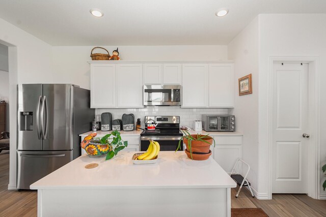 5201 Rockrose Ln, Princeton, TX 75407 - kitchen featuring stainless steel appliances, white cabinets, decorative backsplash, light wood-type flooring, and recessed lighting