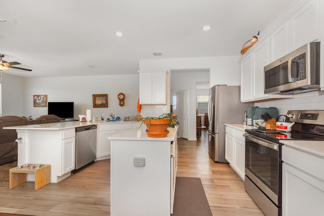 5201 Rockrose Ln, Princeton, TX 75407 - kitchen featuring appliances with stainless steel finishes, a peninsula, open floor plan, decorative backsplash, and light countertops