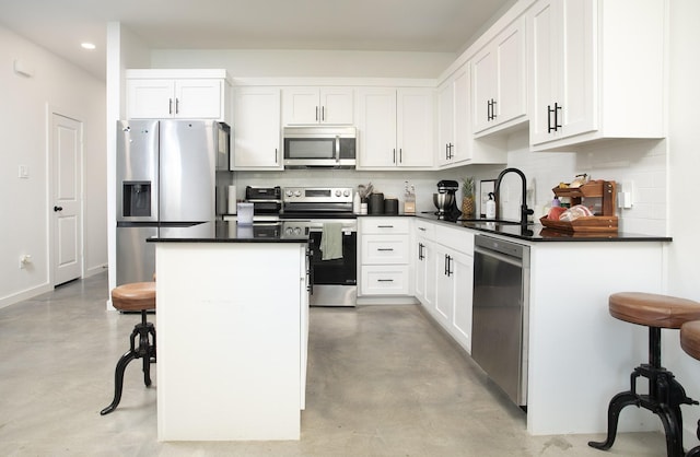 18747 Fm 2493, Flint, TX 75762 - kitchen featuring appliances with stainless steel finishes, a sink, finished concrete floors, a kitchen island, and decorative backsplash