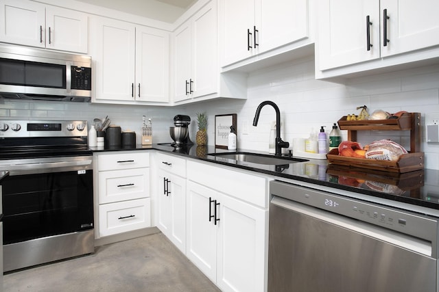 18747 Fm 2493, Flint, TX 75762 - kitchen featuring appliances with stainless steel finishes, a sink, decorative backsplash, concrete floors, and white cabinetry