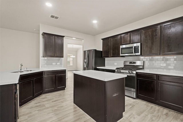 906 Silverbell St, Princeton, TX 75407 - kitchen with stainless steel appliances, decorative backsplash, light countertops, light wood-style floors, and dark brown cabinets