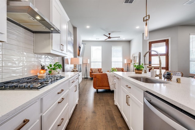 8977 George Cayley Ln, Frisco, TX 75034 - kitchen featuring wall chimney exhaust hood, a sink, appliances with stainless steel finishes, ceiling fan, and dark wood finished floors