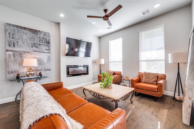 8977 George Cayley Ln, Frisco, TX 75034 - living room with ceiling fan, baseboards, wood finished floors, a glass covered fireplace, and recessed lighting