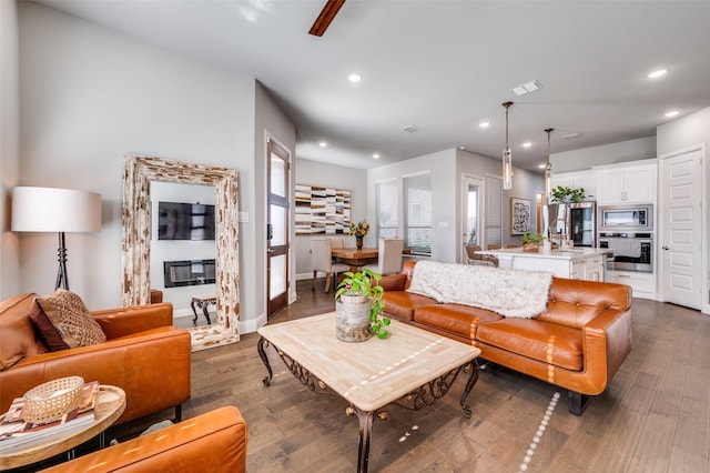8977 George Cayley Ln, Frisco, TX 75034 - living room with recessed lighting, dark wood-type flooring, and baseboards
