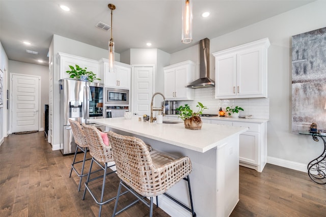 8977 George Cayley Ln, Frisco, TX 75034 - kitchen featuring appliances with stainless steel finishes, wall chimney range hood, a sink, dark wood-style floors, and white cabinets
