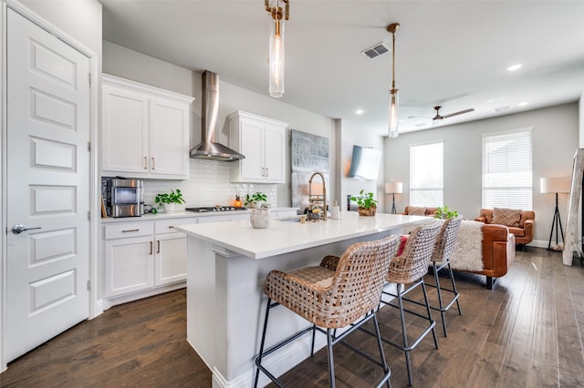 8977 George Cayley Ln, Frisco, TX 75034 - kitchen featuring wall chimney range hood, a sink, open floor plan, white cabinetry, and recessed lighting