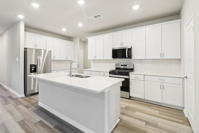 901 Lily Ln, Lavon, TX 75166 - kitchen with stainless steel appliances, a sink, a kitchen island with sink, light wood-style flooring, and recessed lighting