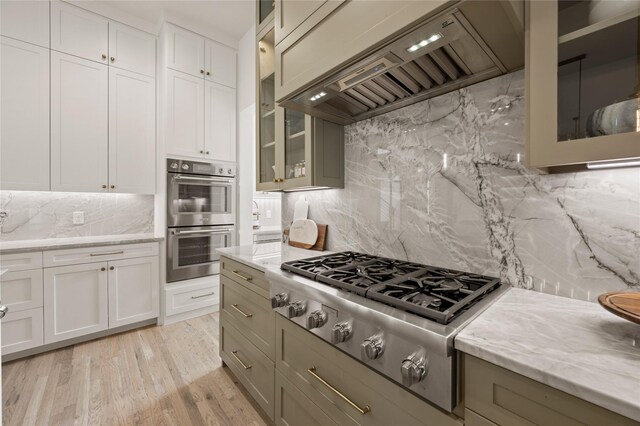 3313 Jackson Ct, Grapevine, TX 76092 - kitchen with appliances with stainless steel finishes, custom exhaust hood, decorative backsplash, glass insert cabinets, and light stone counters