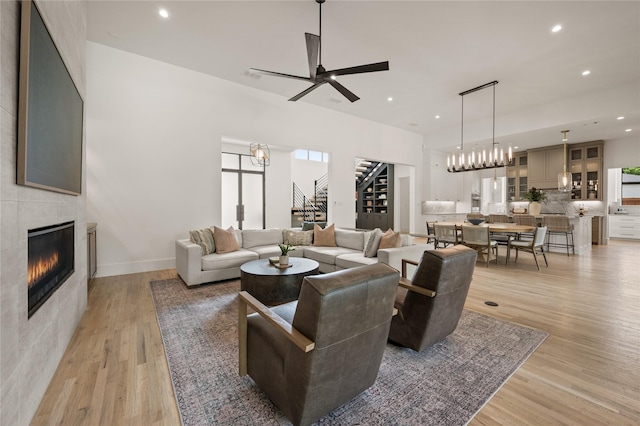3313 Jackson Ct, Grapevine, TX 76092 - living room featuring stairs, light wood finished floors, recessed lighting, a fireplace, and a chandelier
