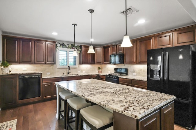 8829 Cantina Bay Ln, Frisco, TX 75036 - kitchen with black appliances, a sink, a kitchen island, dark brown cabinets, and recessed lighting