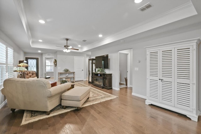 8829 Cantina Bay Ln, Frisco, TX 75036 - living room with a raised ceiling, wood-type flooring, crown molding, a ceiling fan, and recessed lighting