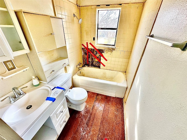 2641 Old Anson Rd, Abilene, TX 79603 - full bathroom featuring toilet, washtub / shower combination, vanity, wood-type flooring, and a textured wall