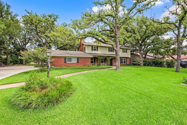 1432 Cimarron Trl, Hurst, TX 76053 - traditional-style home with brick siding, a front lawn, a chimney, and concrete driveway