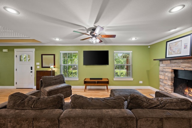 1432 Cimarron Trl, Hurst, TX 76053 - living room featuring ceiling fan, a fireplace, crown molding, light wood finished floors, and baseboards