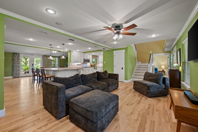 1432 Cimarron Trl, Hurst, TX 76053 - living area featuring crown molding, stairway, baseboards, light wood-type flooring, and ceiling fan