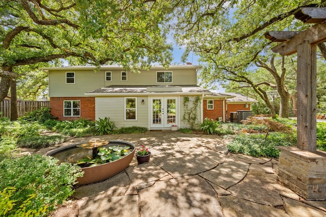 1432 Cimarron Trl, Hurst, TX 76053 - rear view of property featuring french doors, brick siding, and a patio