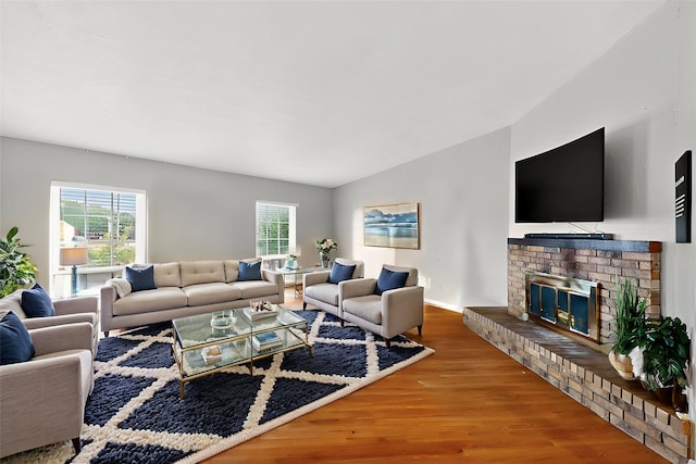 5588 Squires Dr, The Colony, TX 75056 - living area featuring wood finished floors, a fireplace, vaulted ceiling, and baseboards