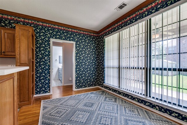 1521 Etain Rd, Irving, TX 75060 - unfurnished dining area featuring wallpapered walls, light wood-style flooring, plenty of natural light, and baseboards