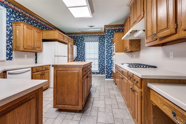 1521 Etain Rd, Irving, TX 75060 - kitchen featuring wallpapered walls, under cabinet range hood, white appliances, light countertops, and a kitchen island