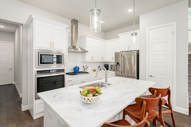4258 Sechrist Dr, Frisco, TX 75034 - kitchen with stainless steel appliances, wall chimney range hood, white cabinetry, decorative backsplash, and a breakfast bar area