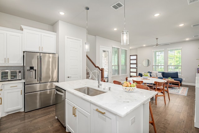 4258 Sechrist Dr, Frisco, TX 75034 - kitchen with stainless steel appliances, open floor plan, dark wood finished floors, white cabinetry, and a ceiling fan