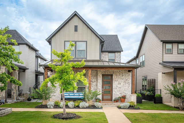 4258 Sechrist Dr, Frisco, TX 75034 - view of front of home with board and batten siding, a front yard, brick siding, a porch, and roof with shingles