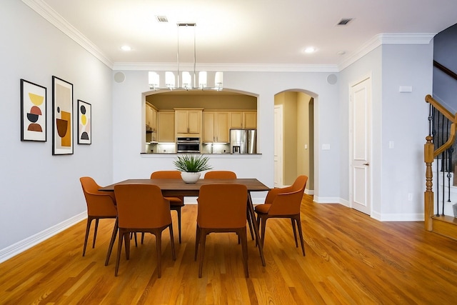 2205 Canton St Unit 107, Dallas, TX 75201 - dining space with light wood-style floors, baseboards, crown molding, arched walkways, and recessed lighting