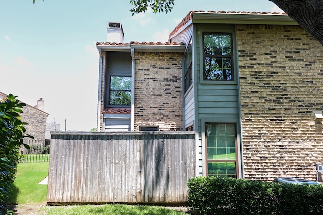 14800 Enterprise Dr Unit 23D, Farmers Branch, TX 75234 - view of side of home featuring brick siding, a chimney, and a tiled roof
