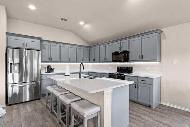 3216 Maroon Creek Rd, Aubrey, TX 76227 - kitchen with black appliances, a sink, light wood finished floors, lofted ceiling, and gray cabinets