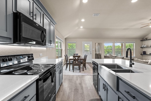 3216 Maroon Creek Rd, Aubrey, TX 76227 - kitchen with black appliances, light countertops, lofted ceiling, a sink, and light wood-style flooring