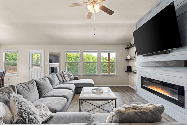 3216 Maroon Creek Rd, Aubrey, TX 76227 - living room with vaulted ceiling, light wood-style floors, a ceiling fan, a large fireplace, and baseboards
