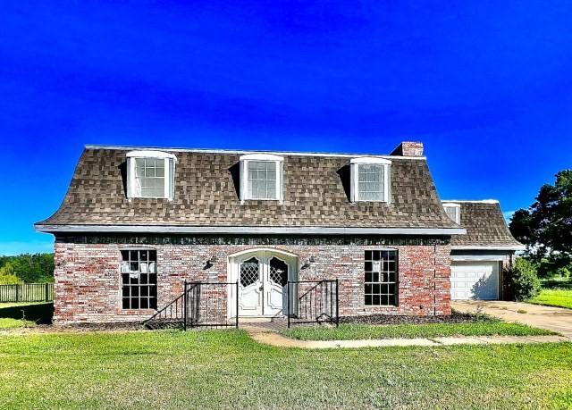 3201 Shoreview Dr, Cleburne, TX 76033 - view of front of home featuring mansard roof, roof with shingles, a garage, a chimney, and a front yard