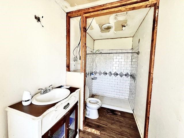 3201 Shoreview Dr, Cleburne, TX 76033 - bathroom with toilet, a stall shower, wood finished floors, and vanity