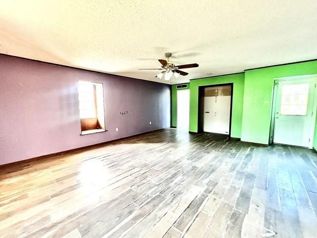 3201 Shoreview Dr, Cleburne, TX 76033 - empty room with wood finished floors, a ceiling fan, a textured ceiling, and baseboards