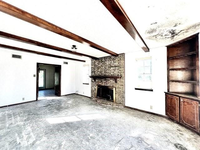 3201 Shoreview Dr, Cleburne, TX 76033 - unfurnished living room with a brick fireplace, beamed ceiling, and baseboards
