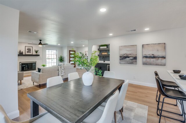 2028 Casa Loma Ct, Grapevine, TX 76051 - dining space with a large fireplace, light wood-style floors, recessed lighting, a ceiling fan, and baseboards