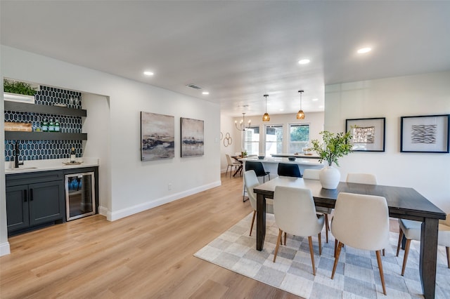 2028 Casa Loma Ct, Grapevine, TX 76051 - dining space with beverage cooler, bar with sink, light wood finished floors, a chandelier, and recessed lighting