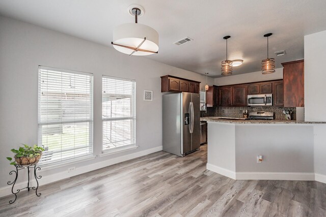 6204 Geneva Ln, Fort Worth, TX 76131 - kitchen featuring stainless steel appliances, light wood-type flooring, backsplash, dark brown cabinetry, and hanging light fixtures