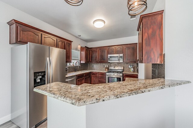 6204 Geneva Ln, Fort Worth, TX 76131 - kitchen with stainless steel appliances, a peninsula, tasteful backsplash, and light stone counters